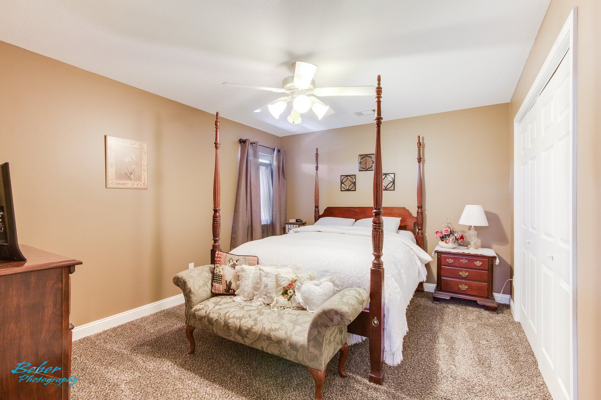 A bedroom with a four poster bed and a bench.