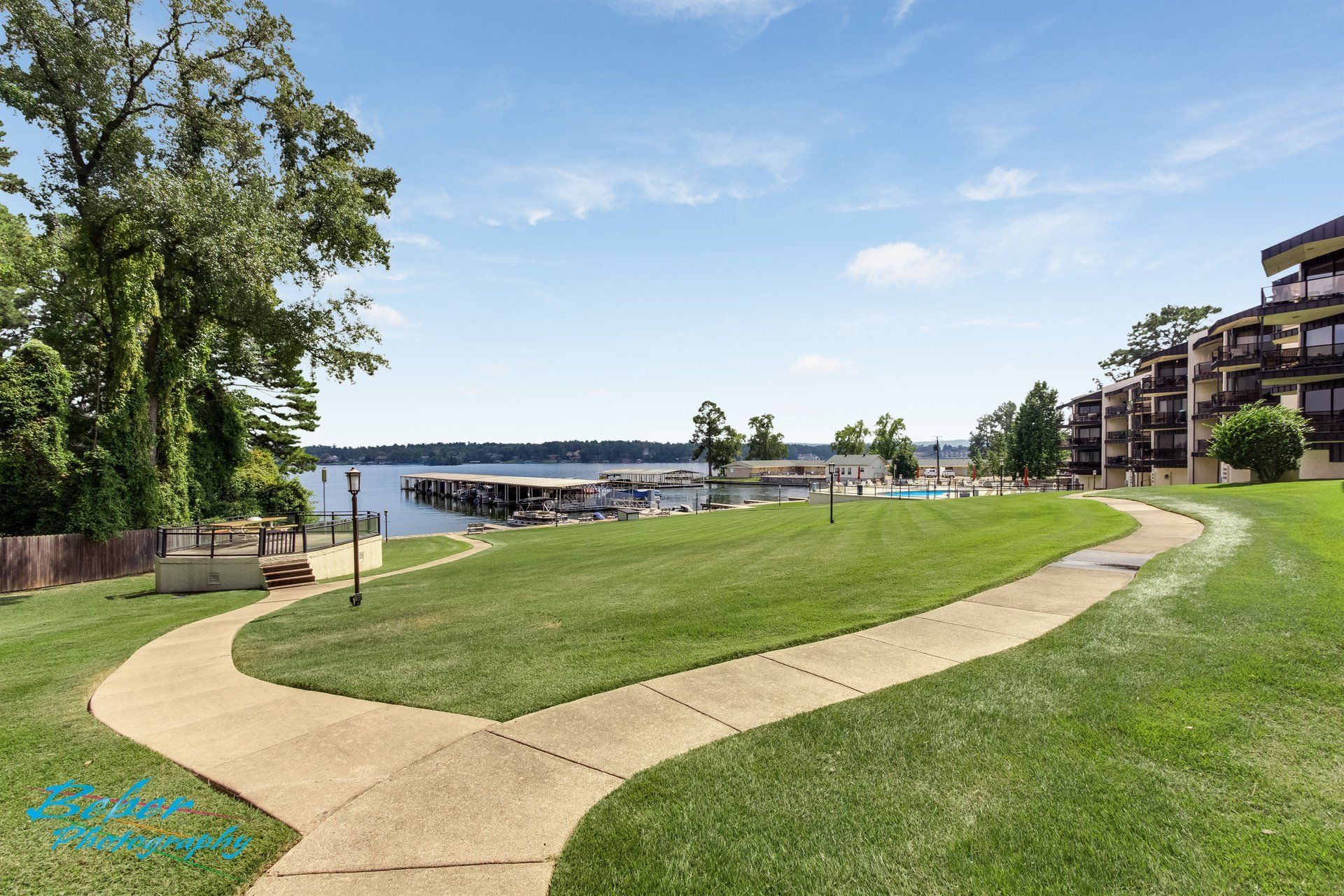A path going through a grassy field with a building in the background