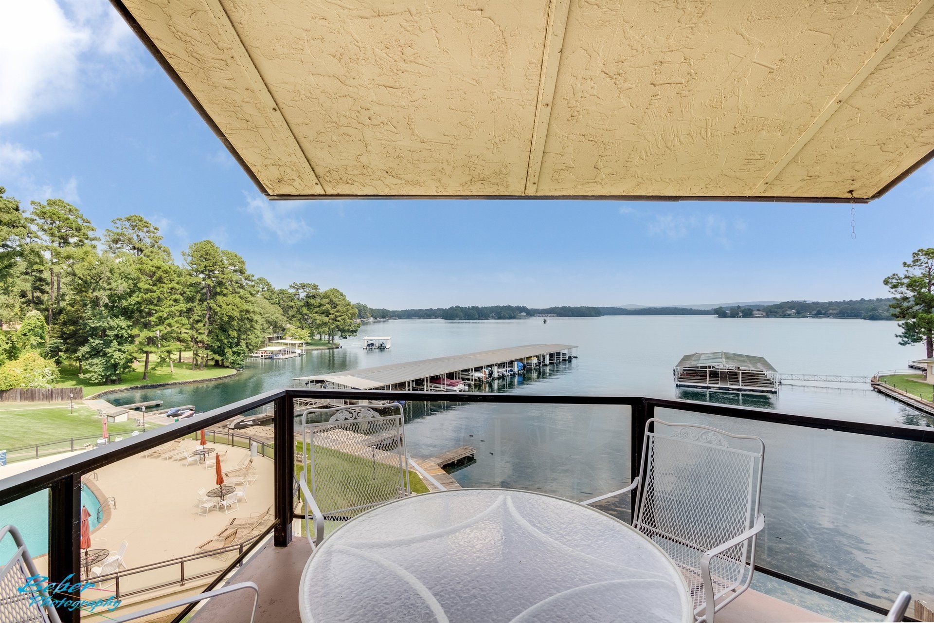 A balcony with a table and chairs overlooking a lake.