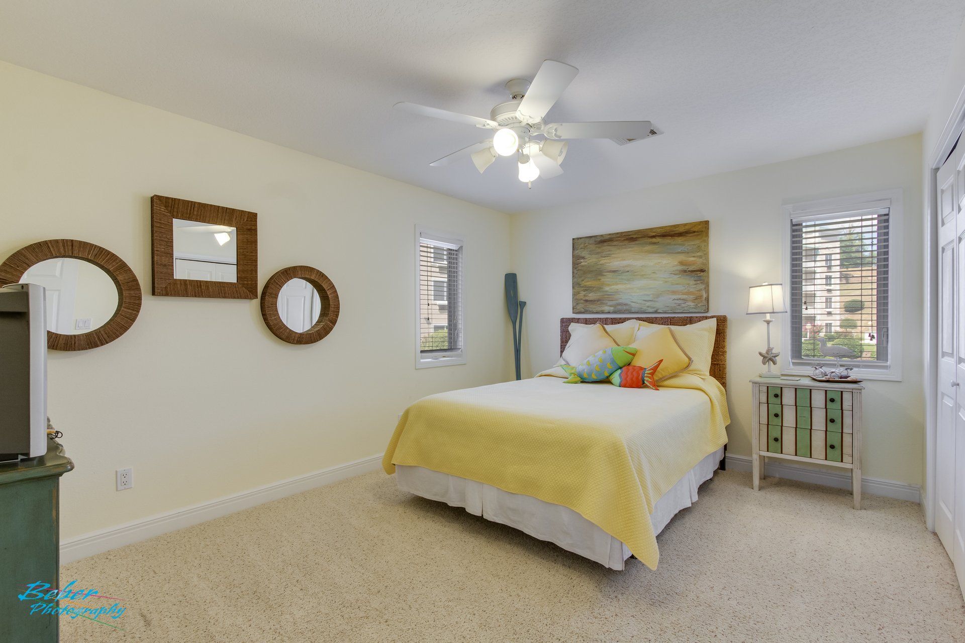 A bedroom with a bed and a ceiling fan.