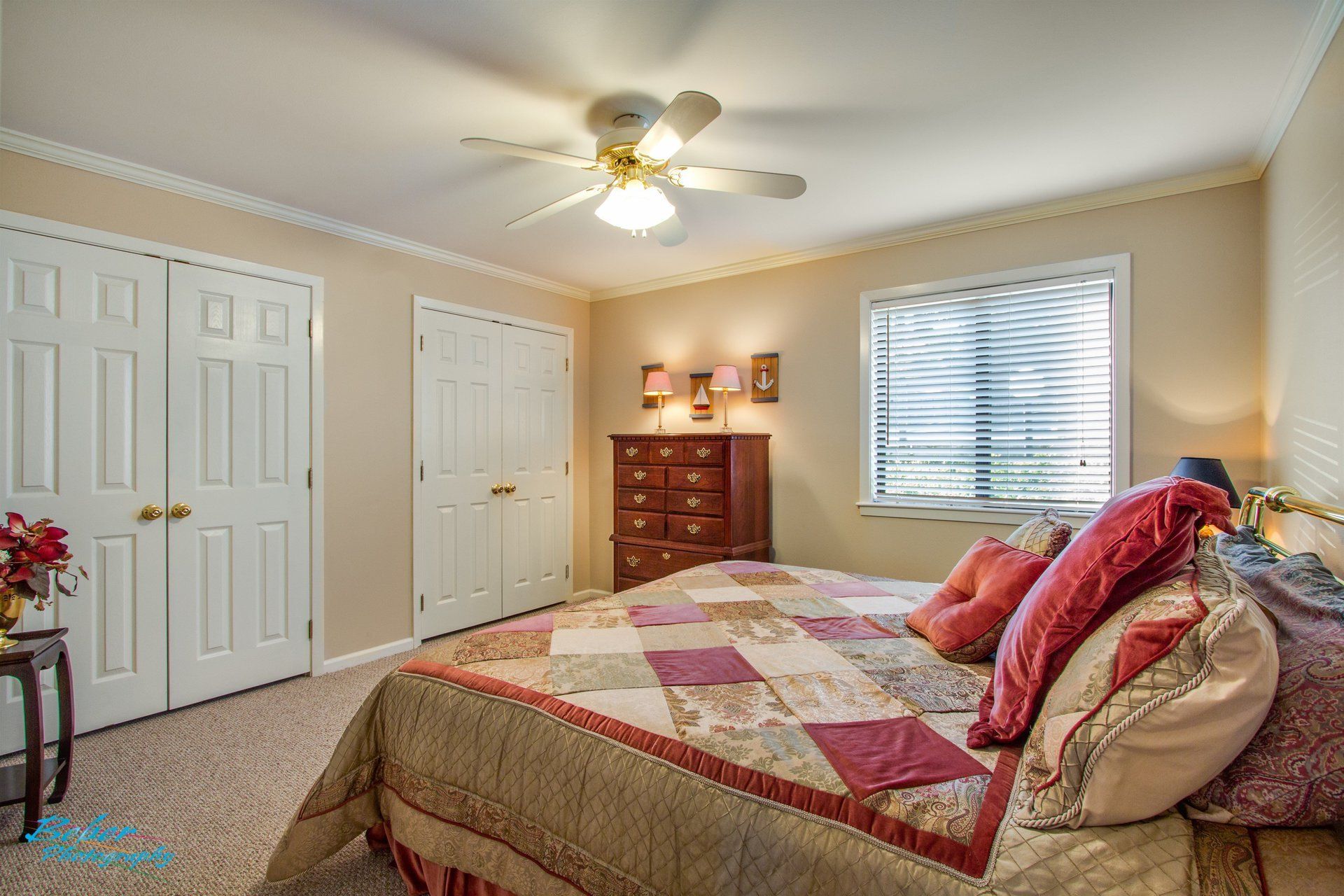 A bedroom with a large bed and a ceiling fan.