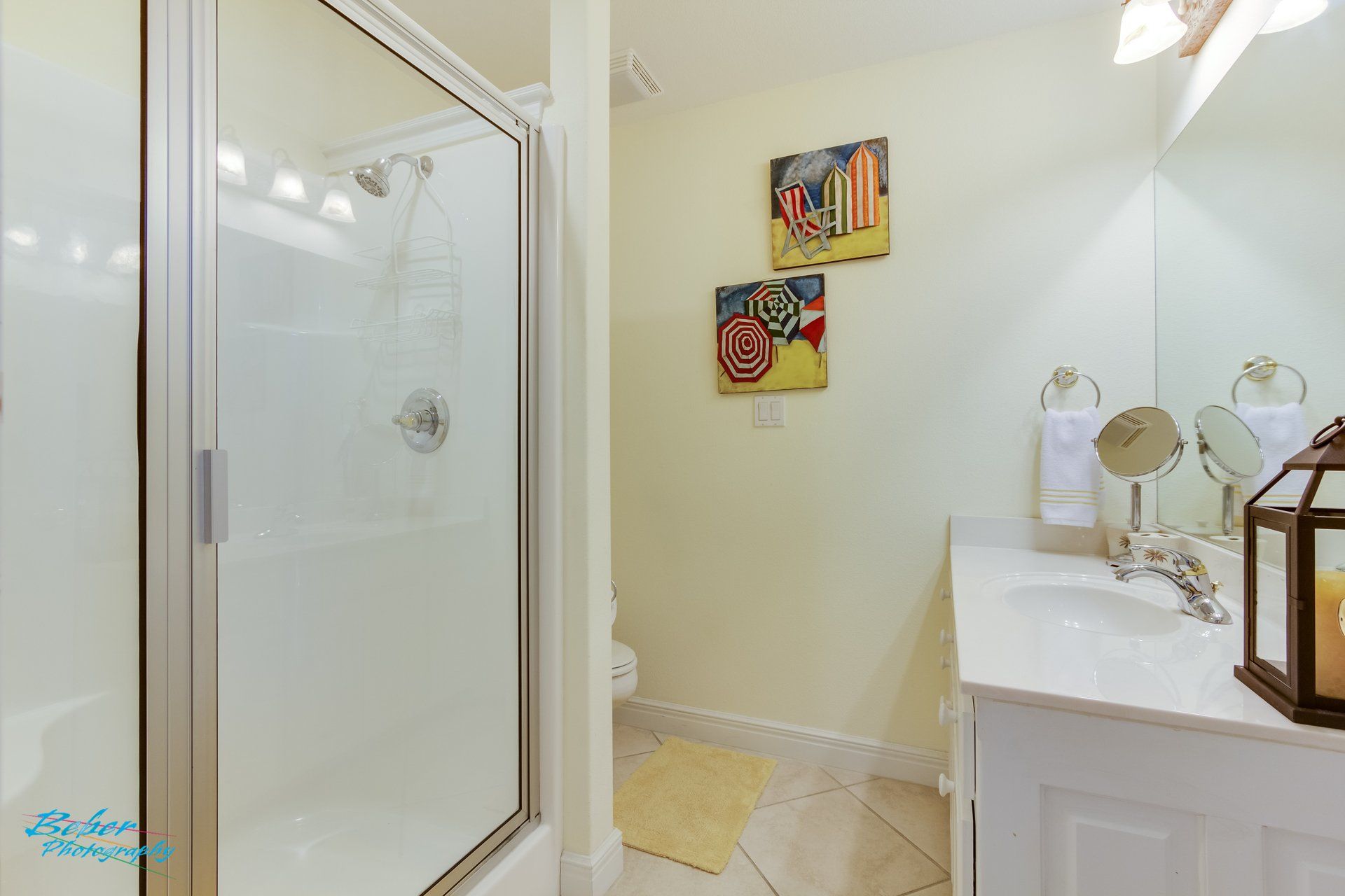 A bathroom with a sink , mirror and walk in shower.