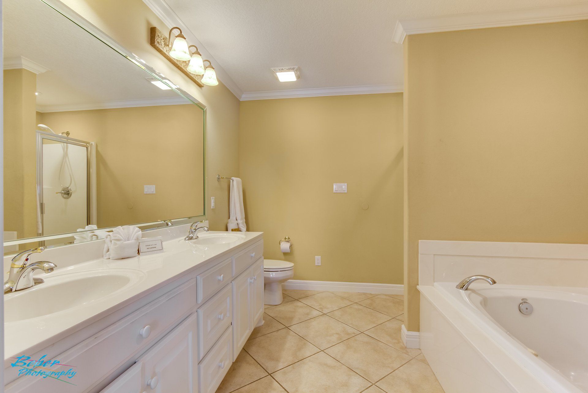 A bathroom with two sinks , a toilet , and a bathtub.