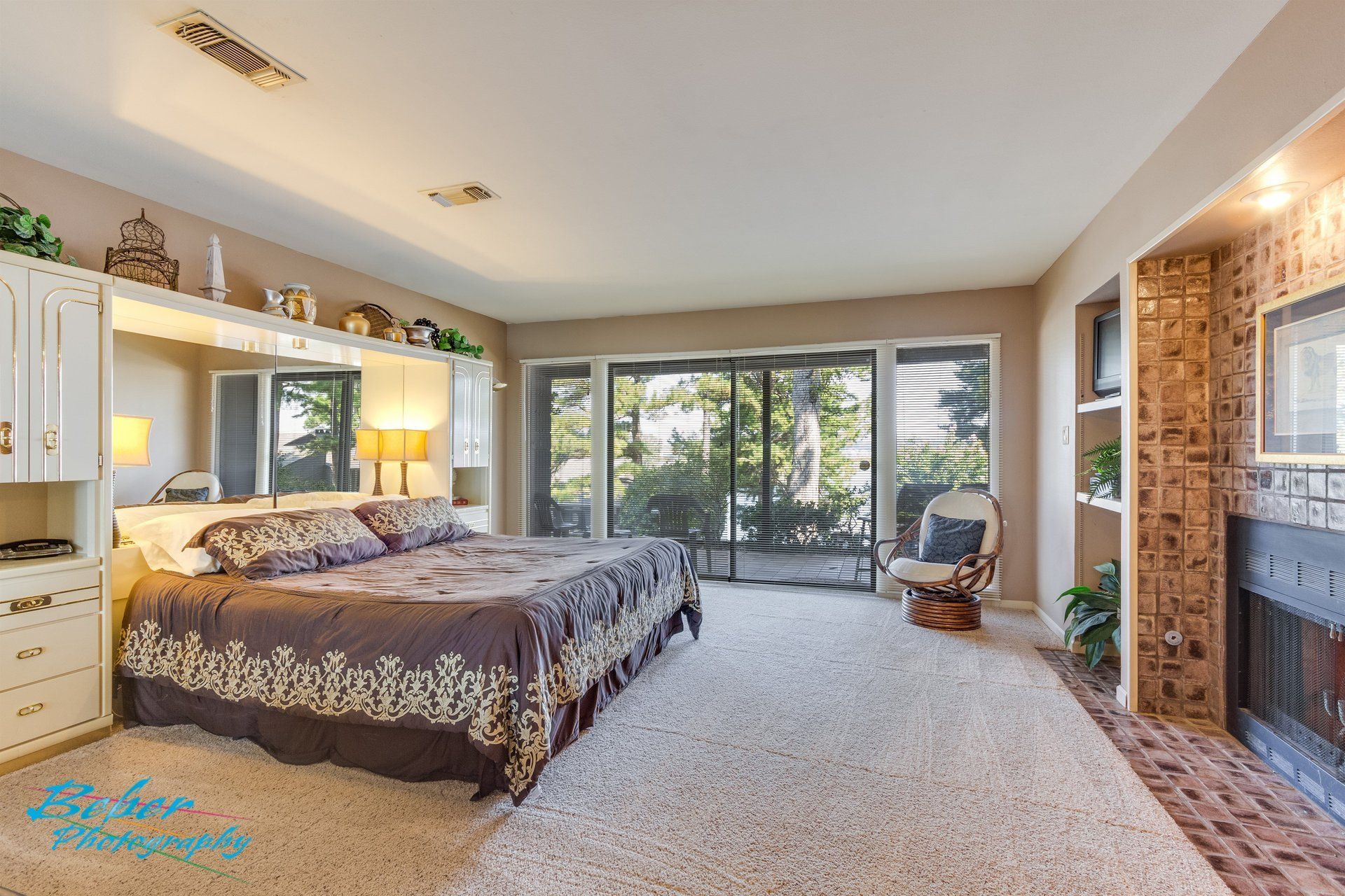 A bedroom with a large bed and a fireplace