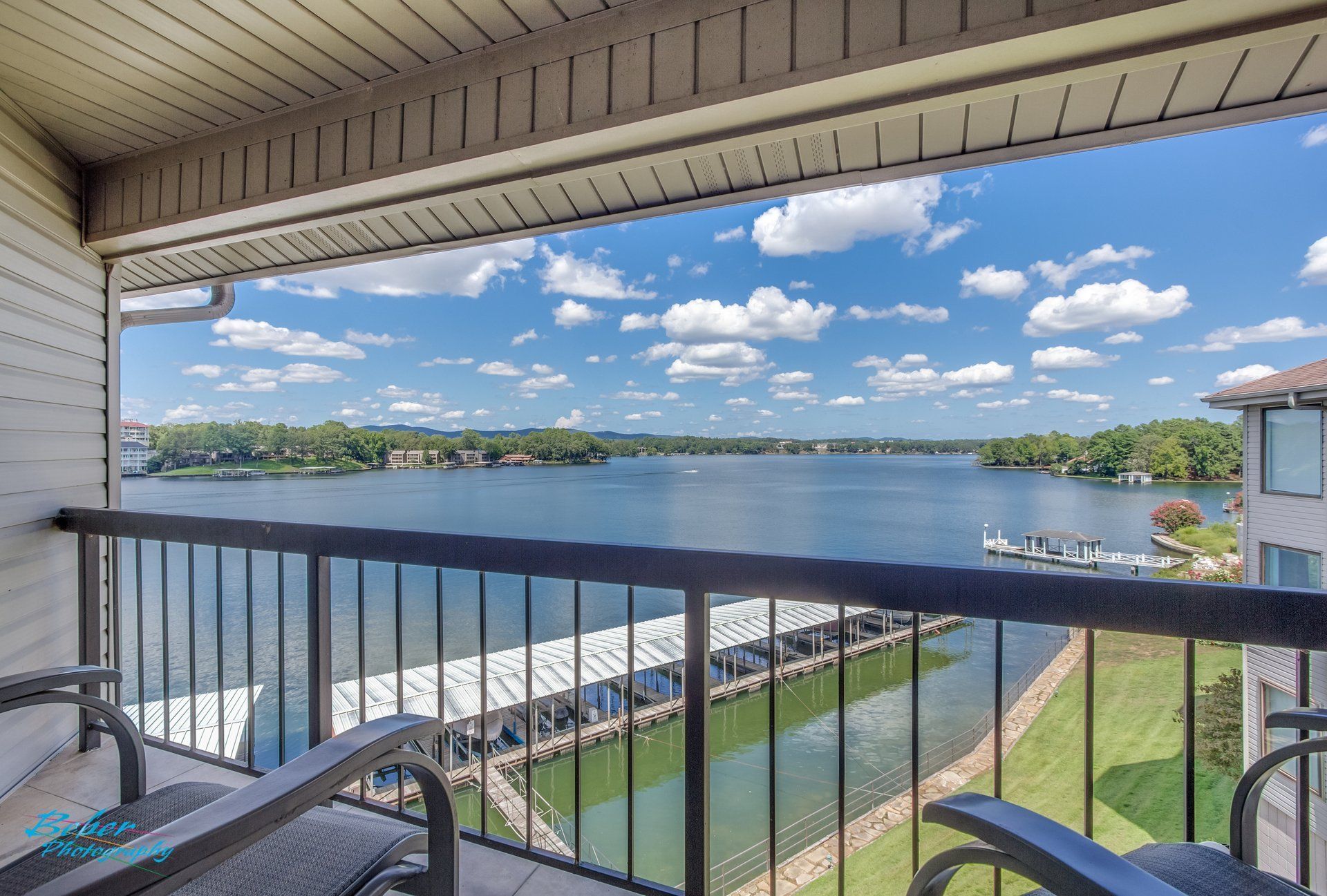 A balcony with a view of a lake and a dock.