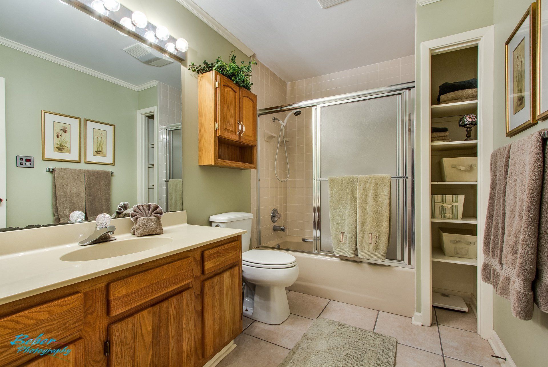 A bathroom with a sink , toilet , shower and closet.