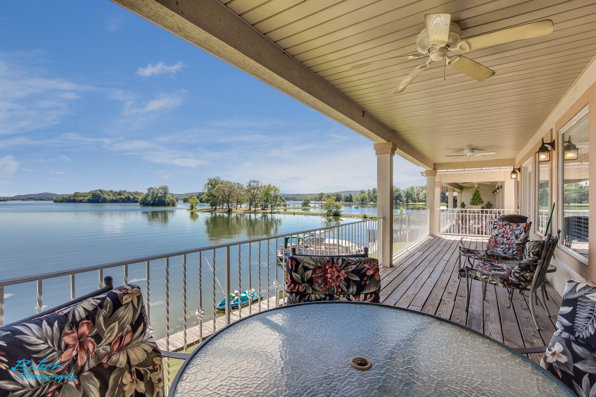A porch with a table and chairs overlooking a lake