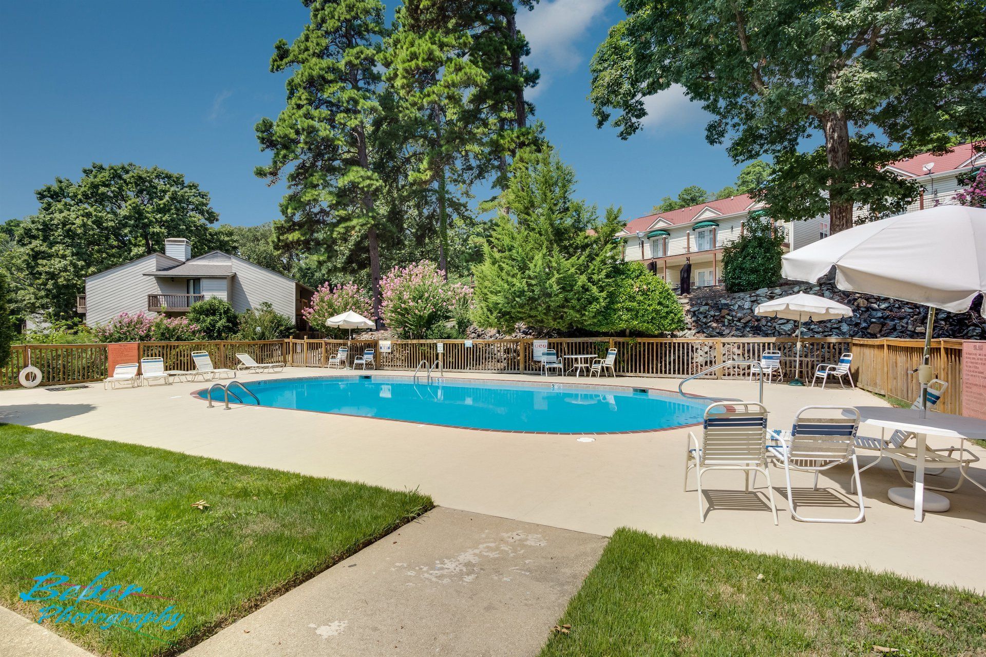A large swimming pool surrounded by chairs and umbrellas