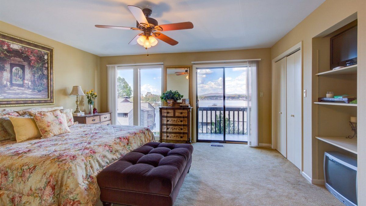 A bedroom with a large bed and a ceiling fan.