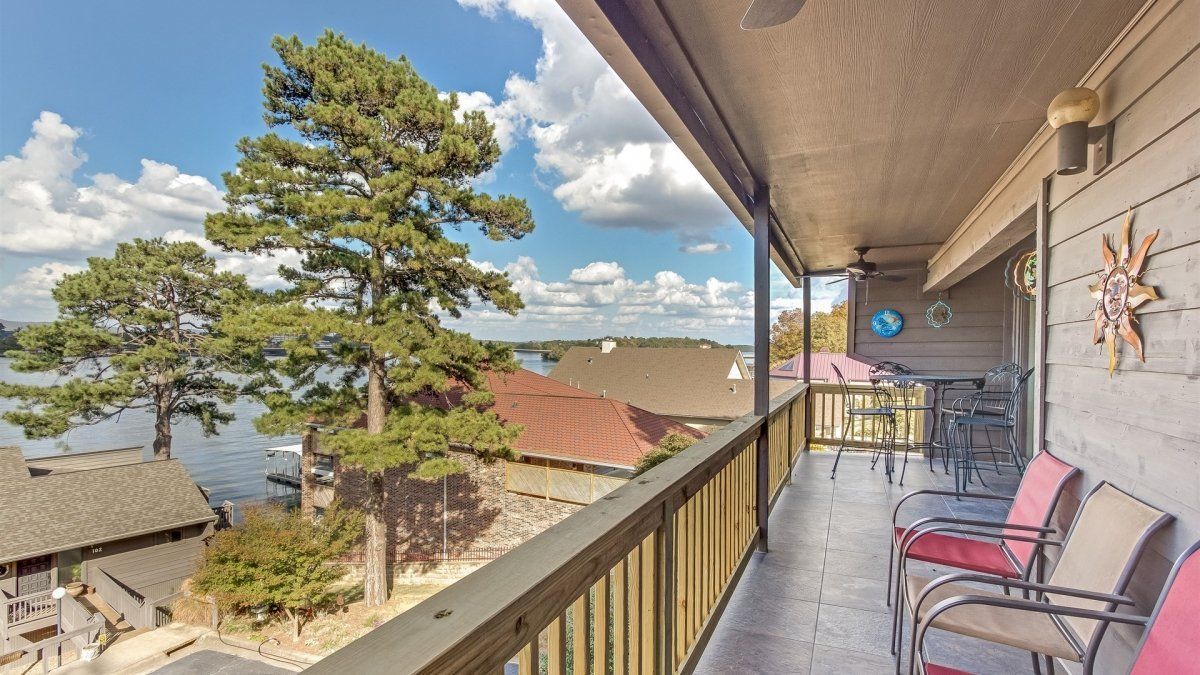 A balcony with a view of a lake and trees.