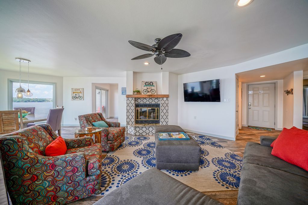 A living room filled with furniture and a fireplace with a ceiling fan.
