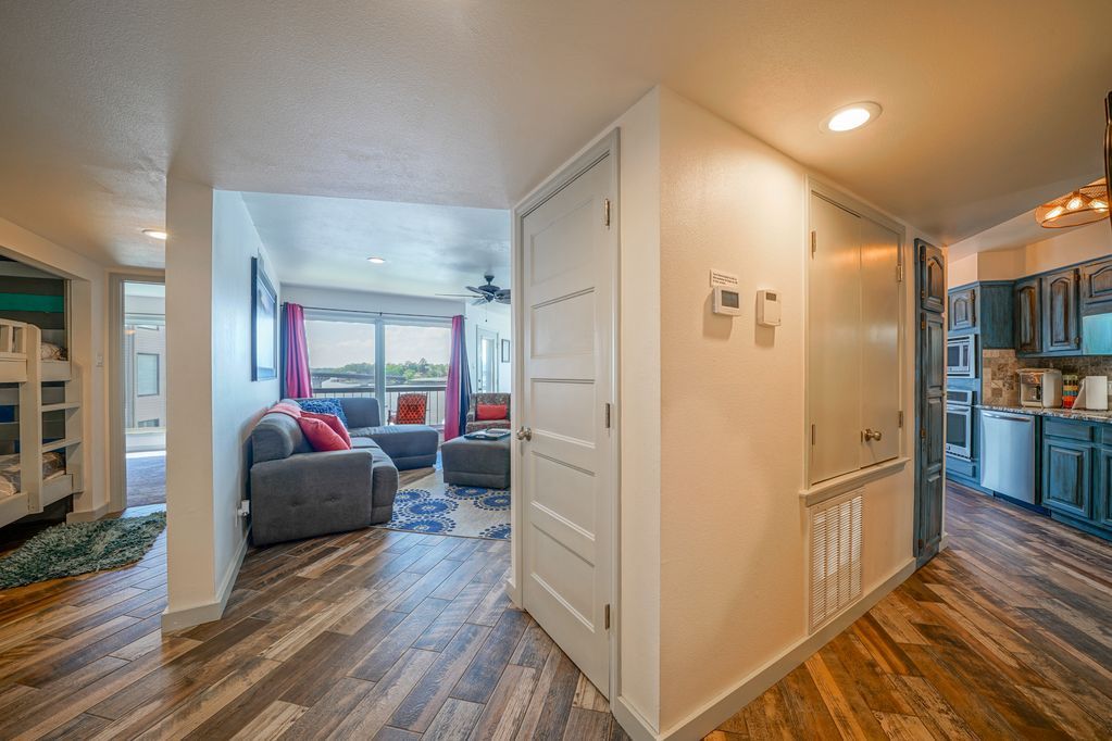 A hallway leading to a living room and kitchen in a house.
