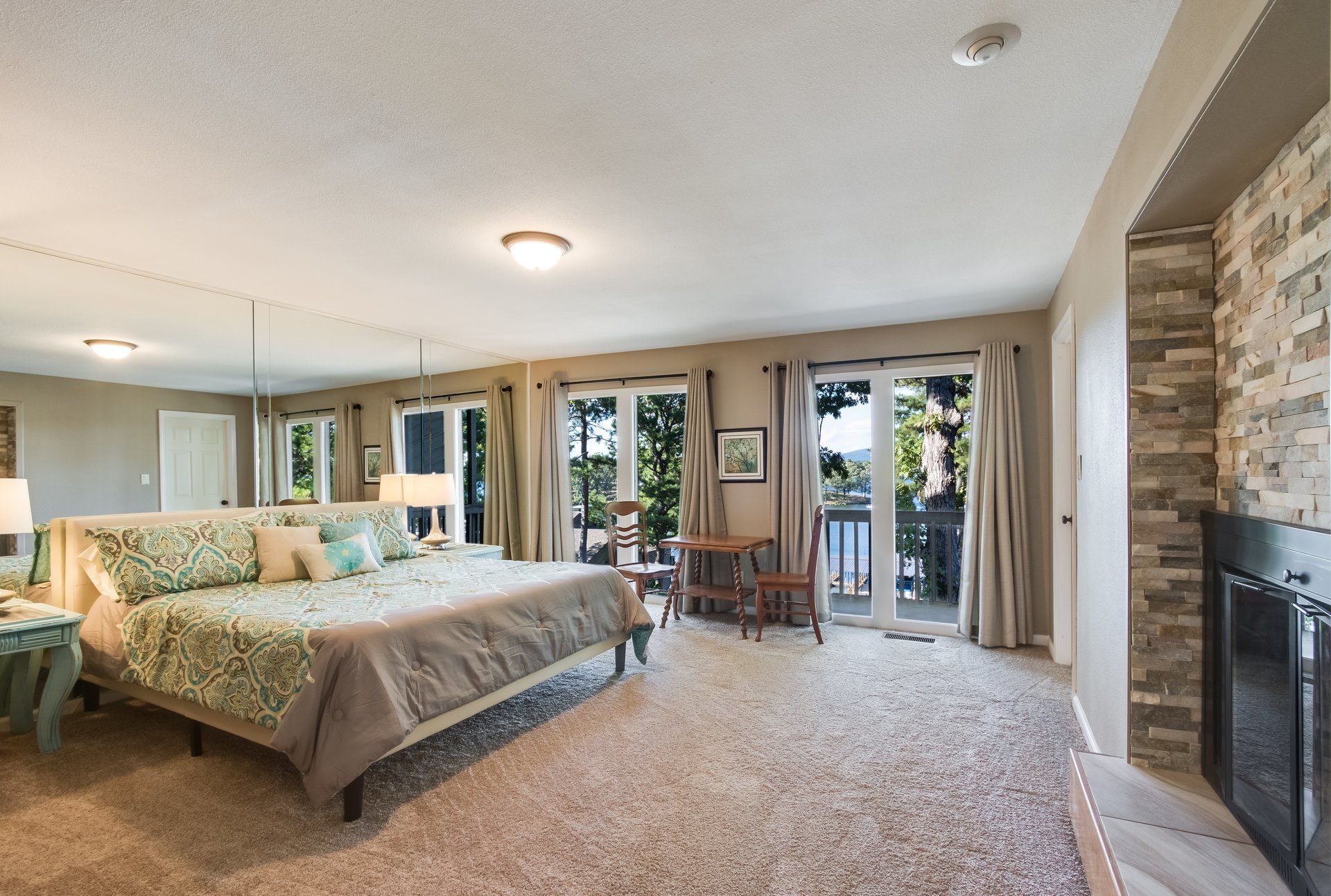 A bedroom with a large bed and a fireplace