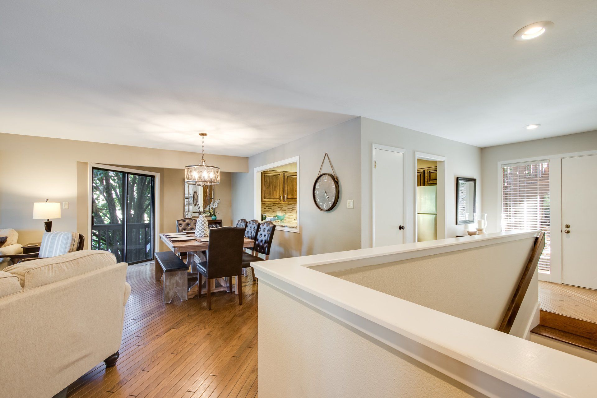 A living room with hardwood floors and a dining room with a table and chairs.