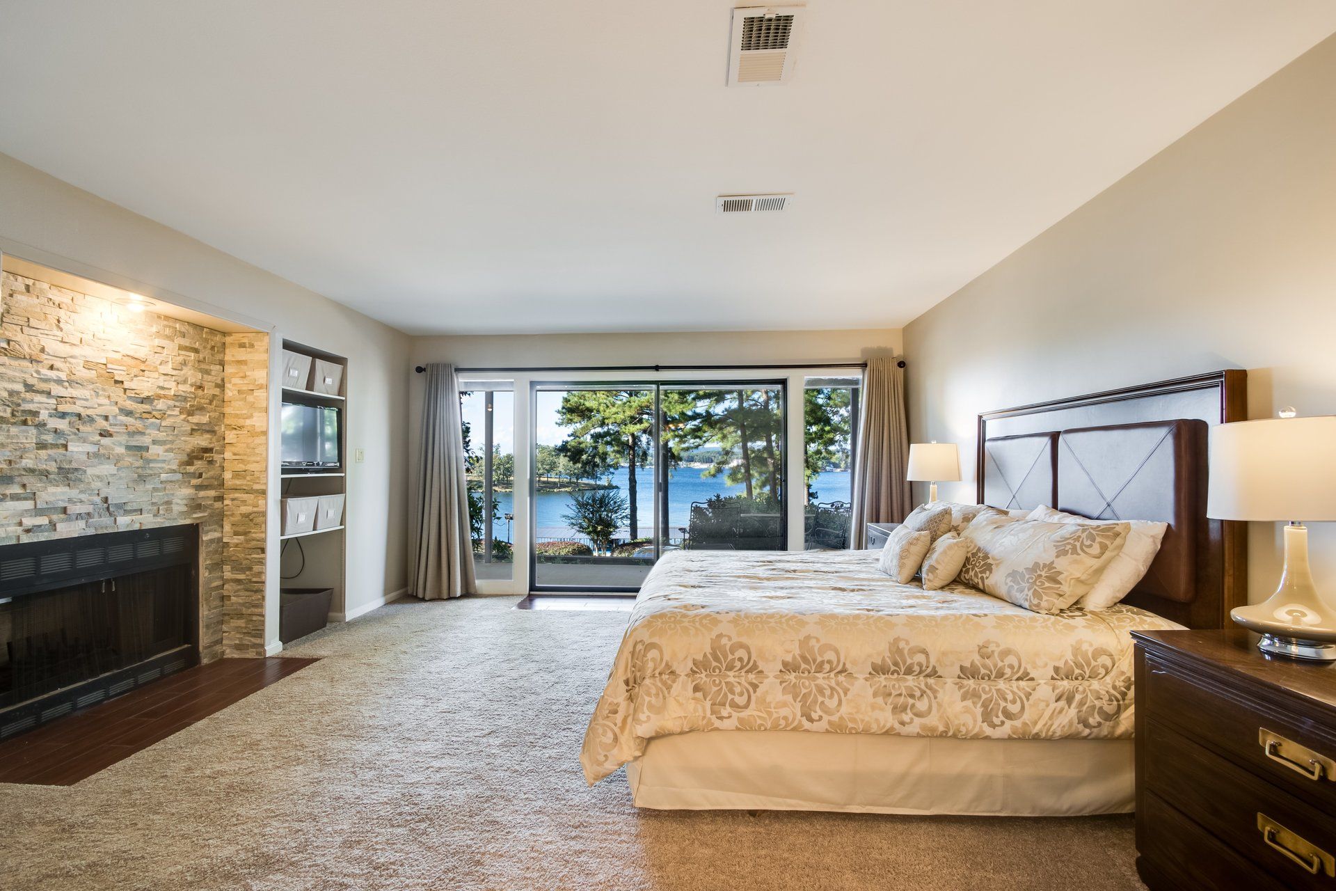 A bedroom with a large bed and a fireplace