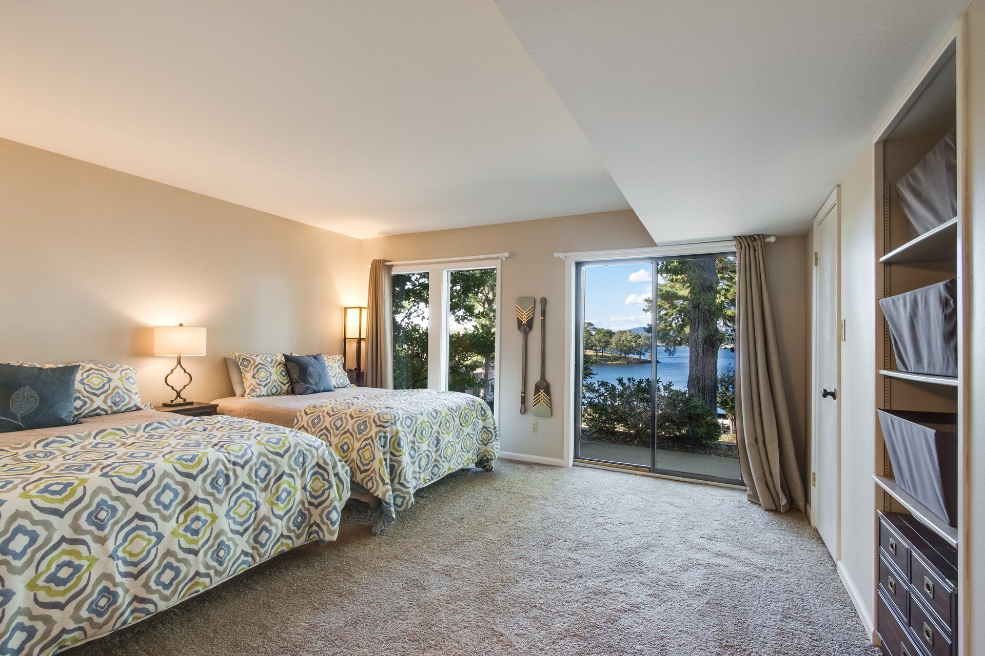 A bedroom with two beds and a view of a lake.