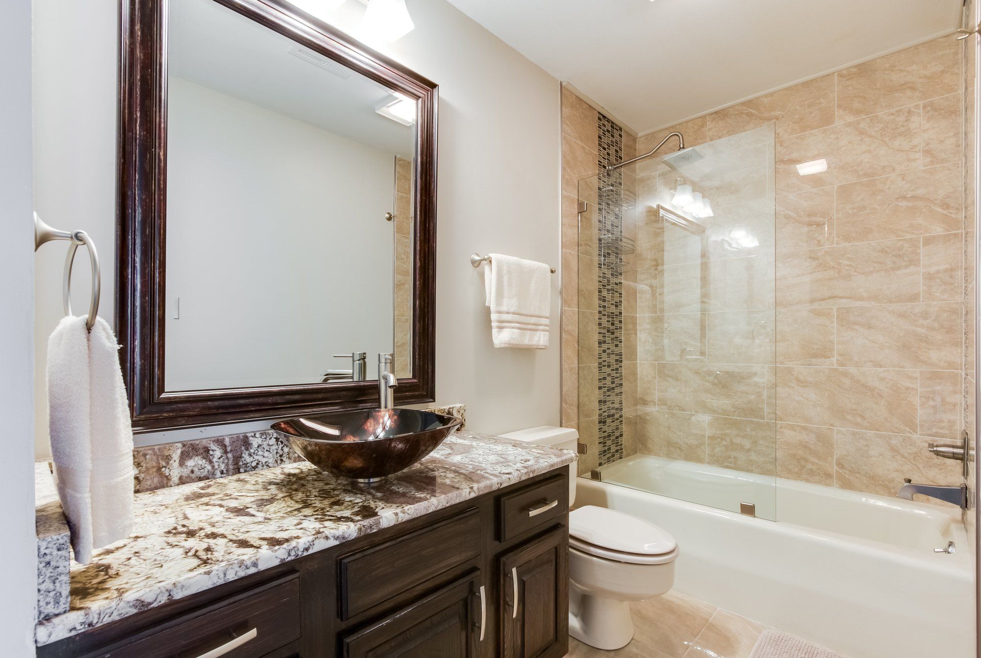 A bathroom with a sink , toilet , tub and mirror.