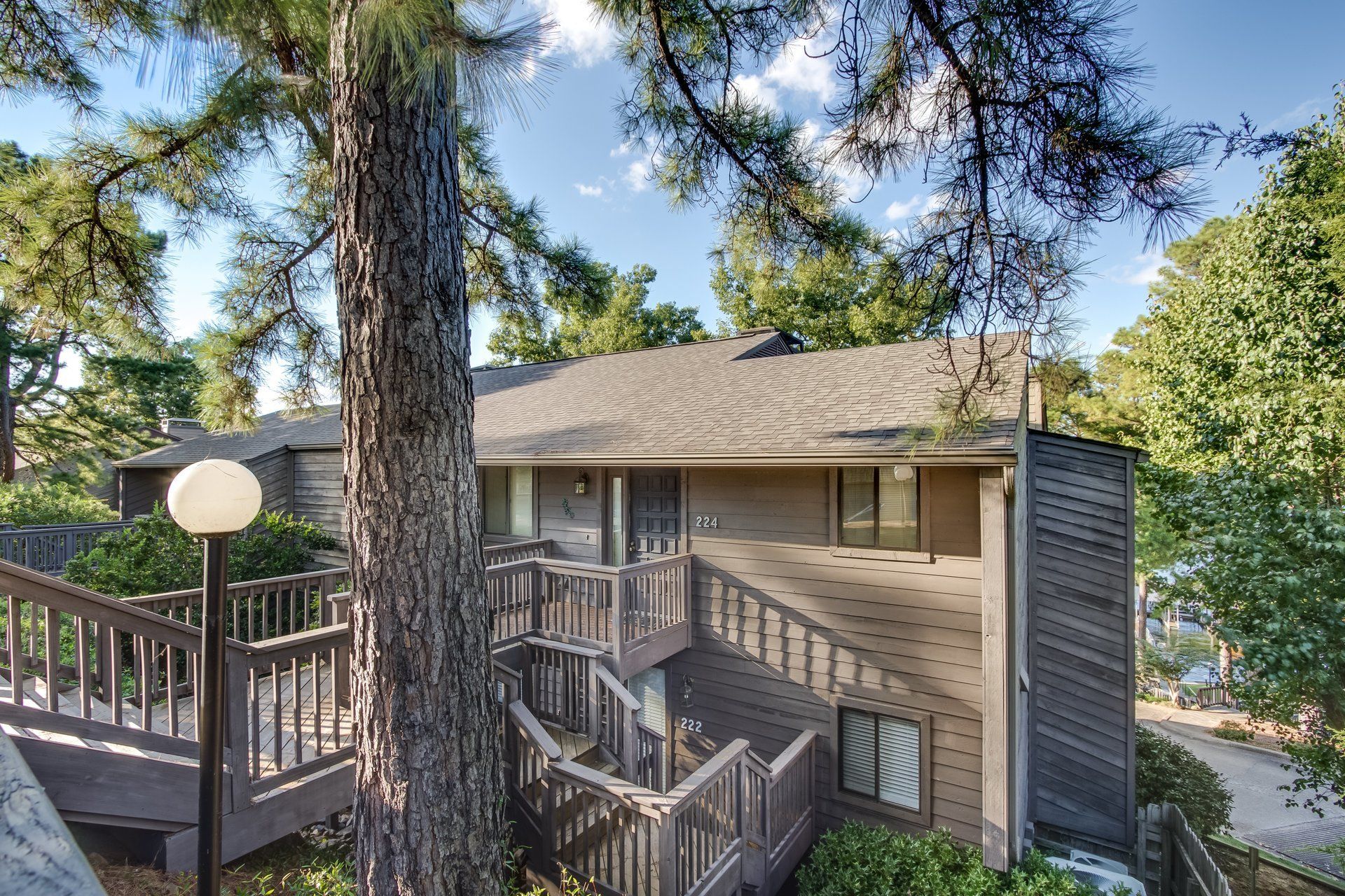 A house with stairs leading up to it is surrounded by trees.