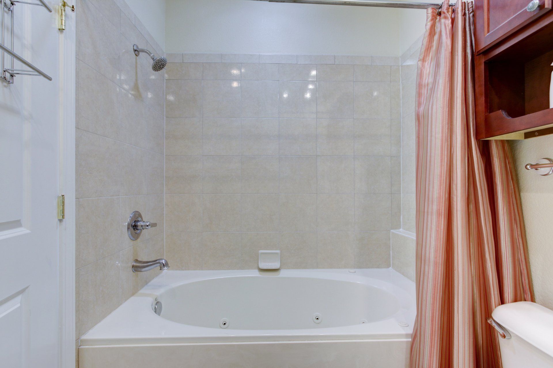 A bathroom with a tub , shower and toilet.