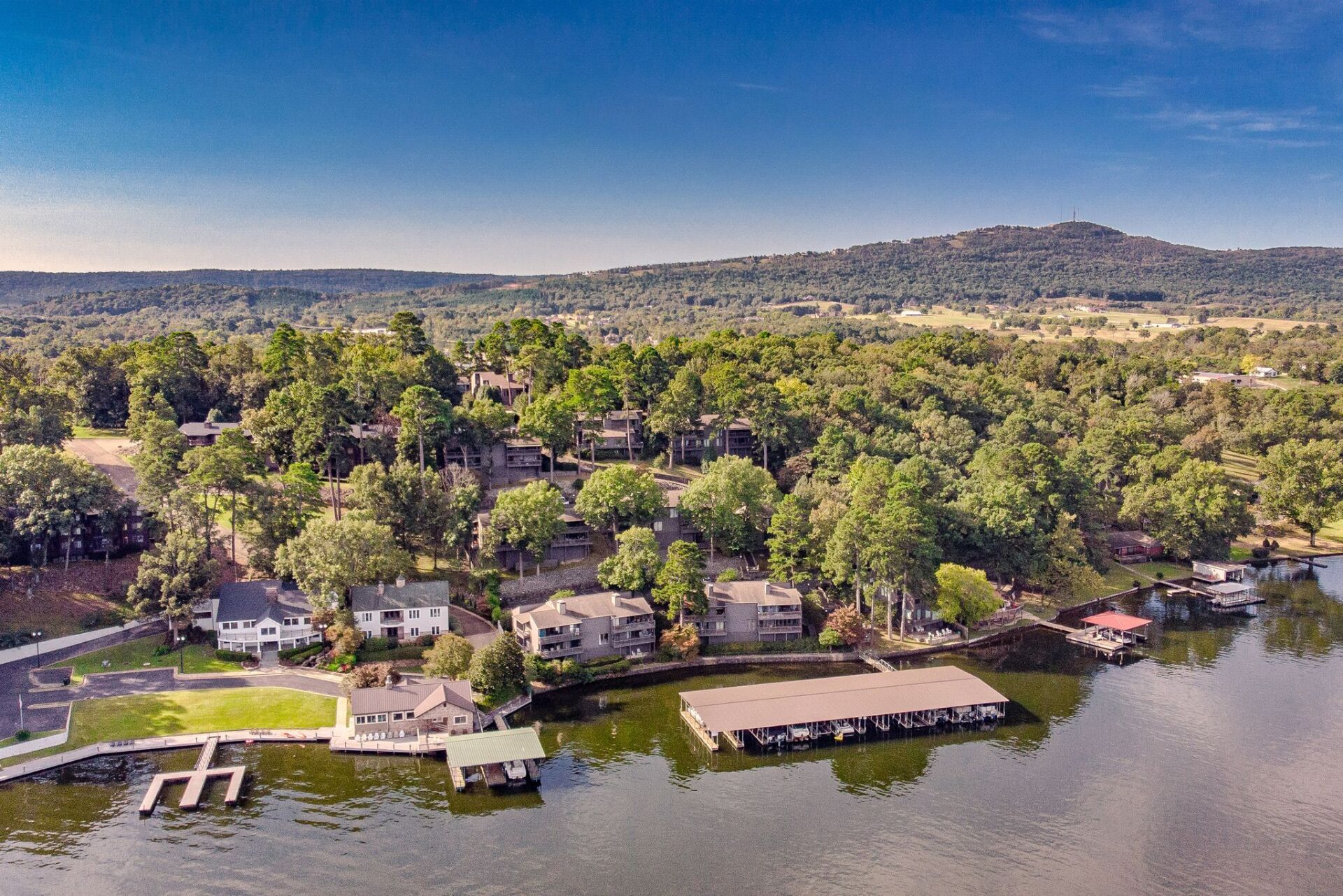 An aerial view of a lake surrounded by trees and houses.