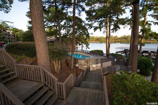 A wooden deck with stairs leading up to a lake
