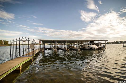 A dock with boats docked at a marina on a lake.