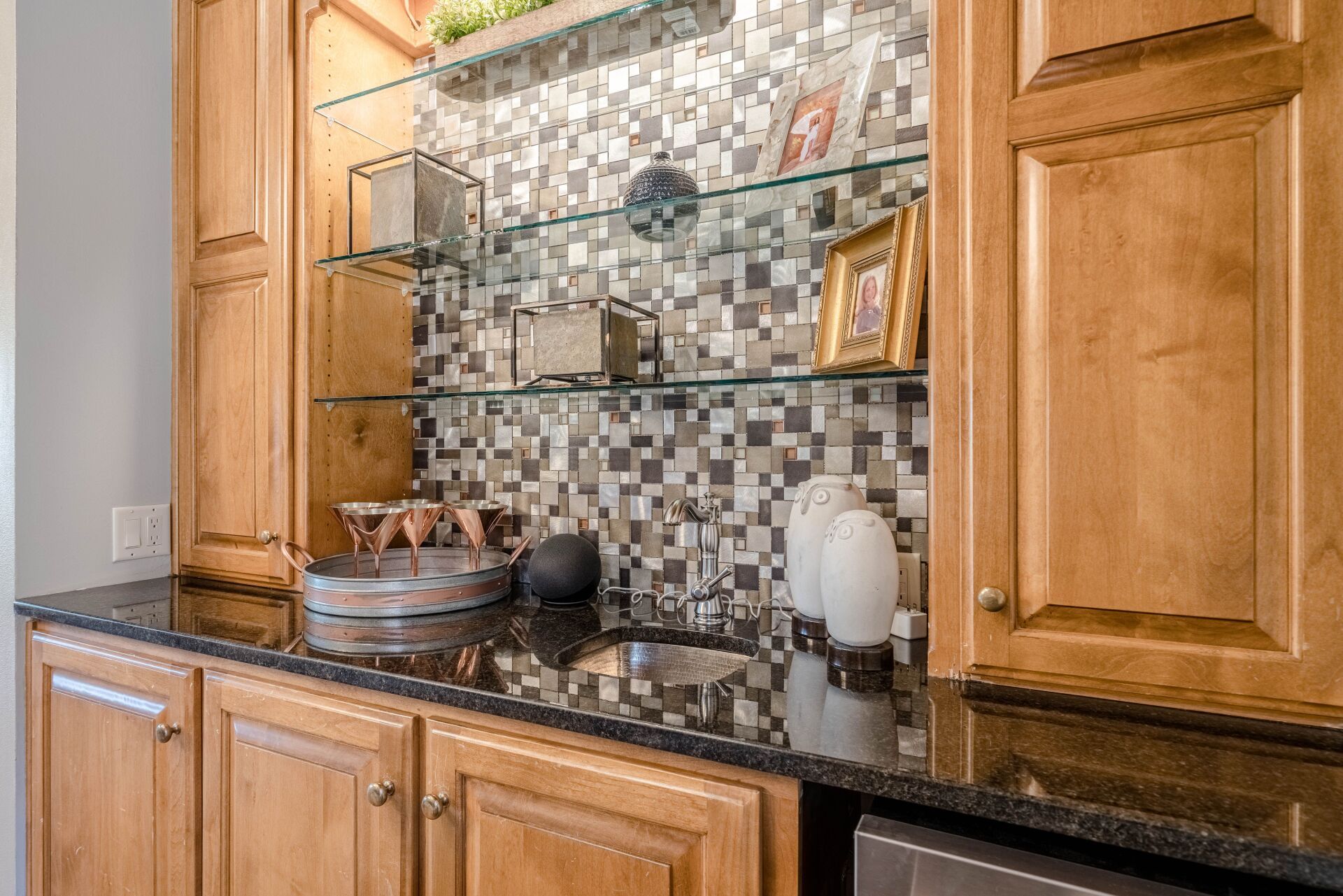 A kitchen with wooden cabinets and black granite counter tops.