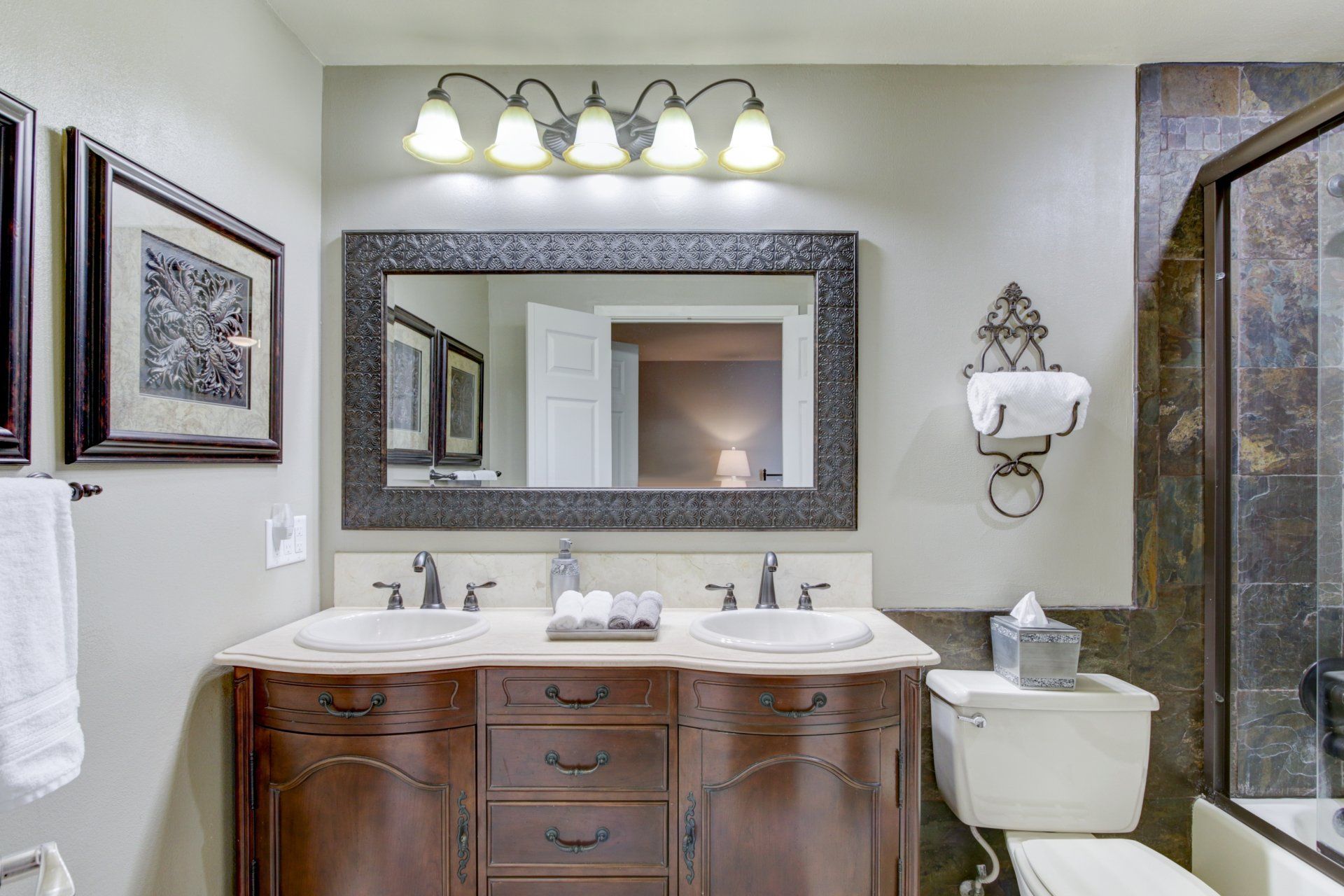 A bathroom with two sinks , a toilet , and a large mirror.