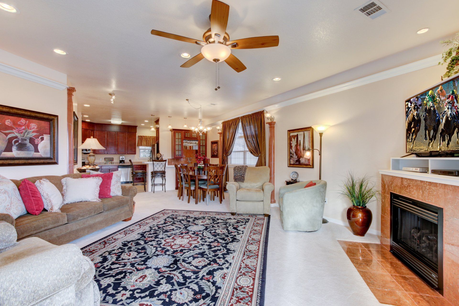 A living room with a fireplace and a ceiling fan