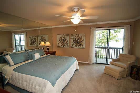 A bedroom with a large bed and a ceiling fan
