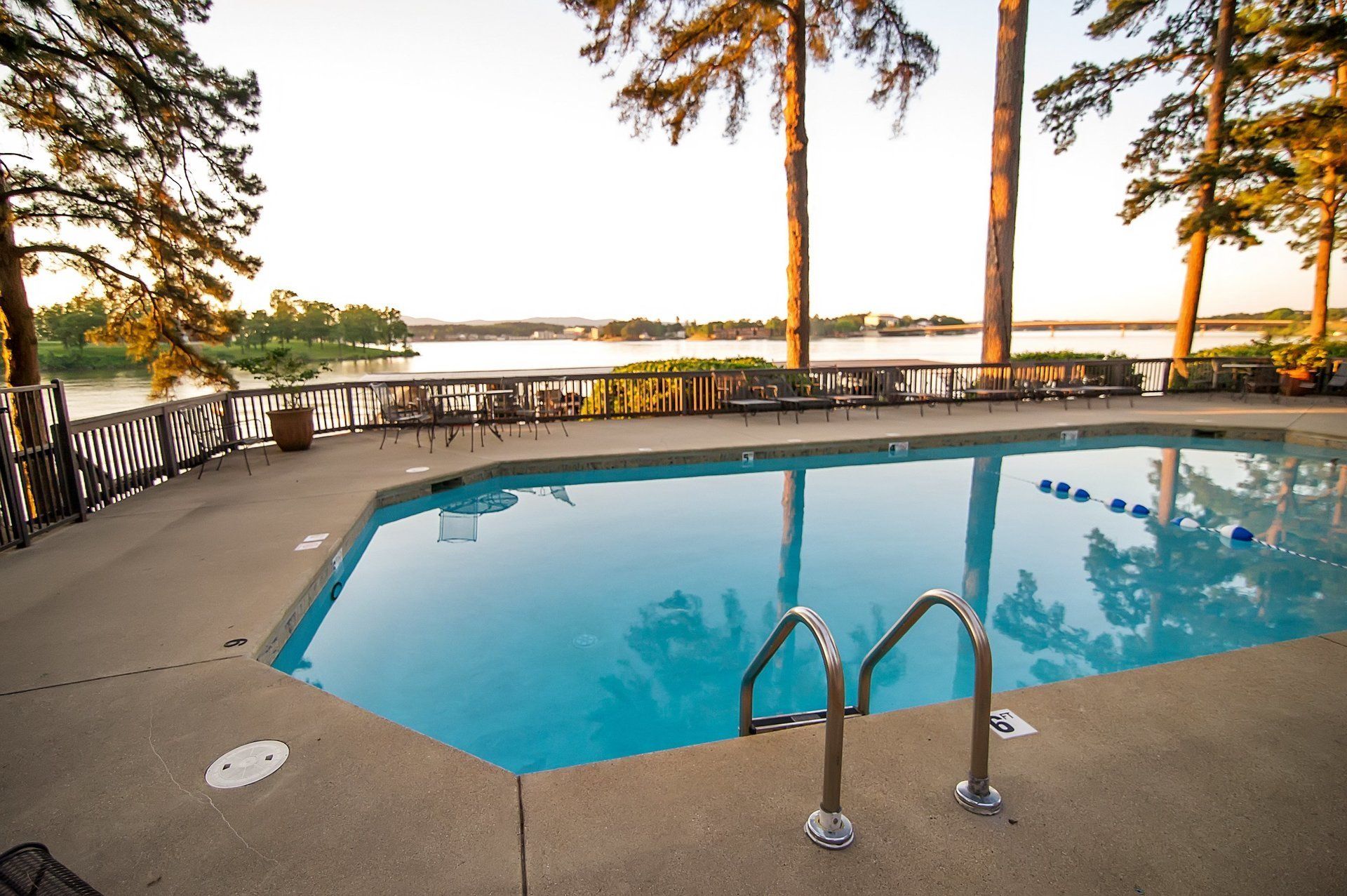A large swimming pool with a view of a lake