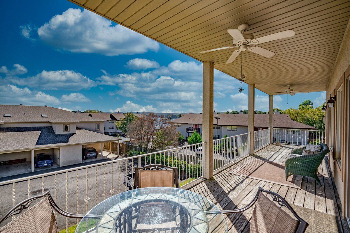 A balcony with a table and chairs and a ceiling fan.