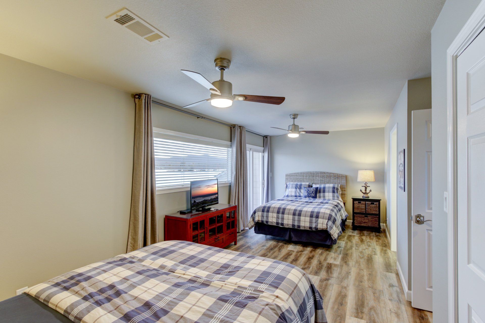 A bedroom with two beds and a ceiling fan.
