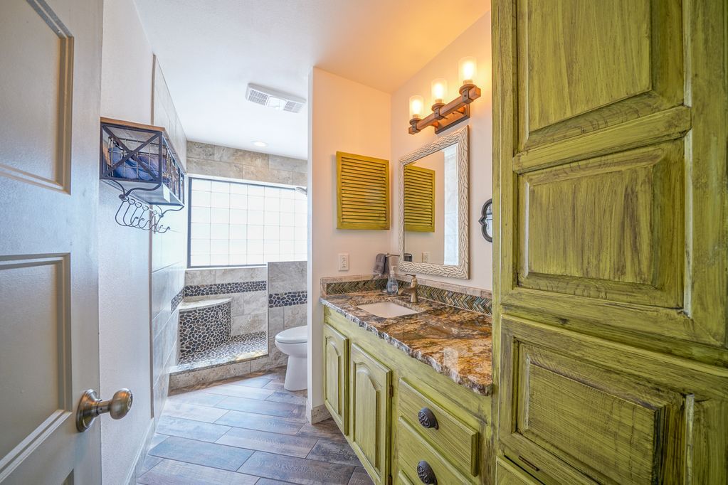 A bathroom with two sinks , a toilet , and a walk in shower.