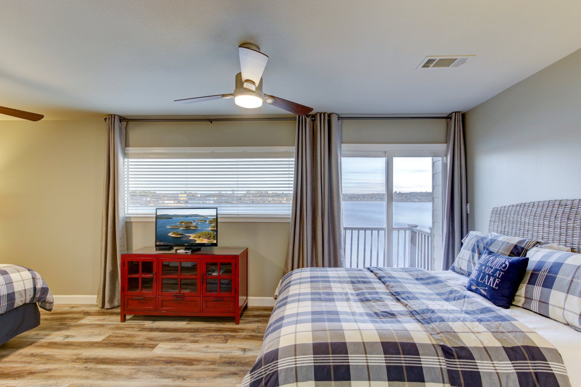 A bedroom with two beds , a ceiling fan , and a television.