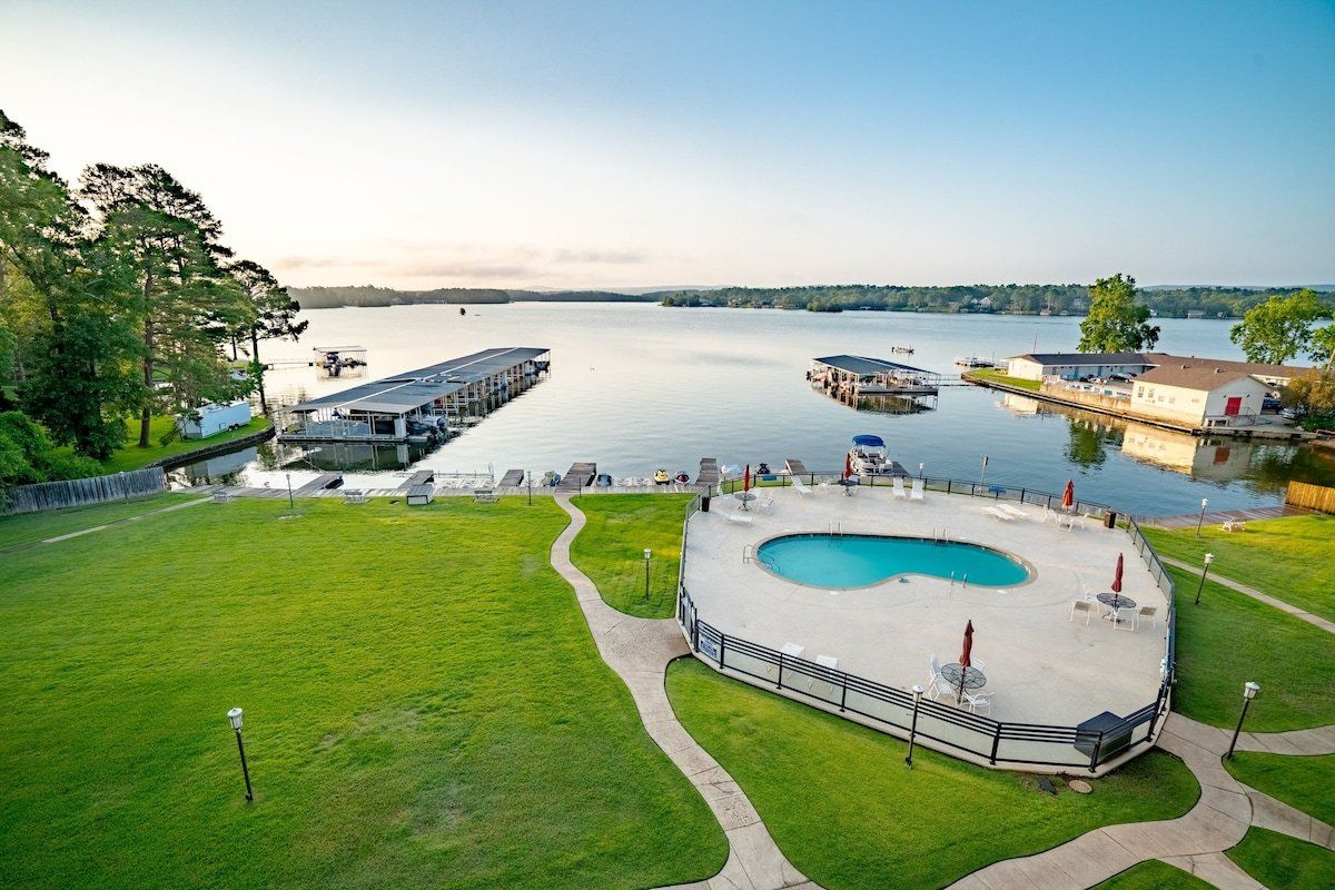 An aerial view of a swimming pool next to a lake.