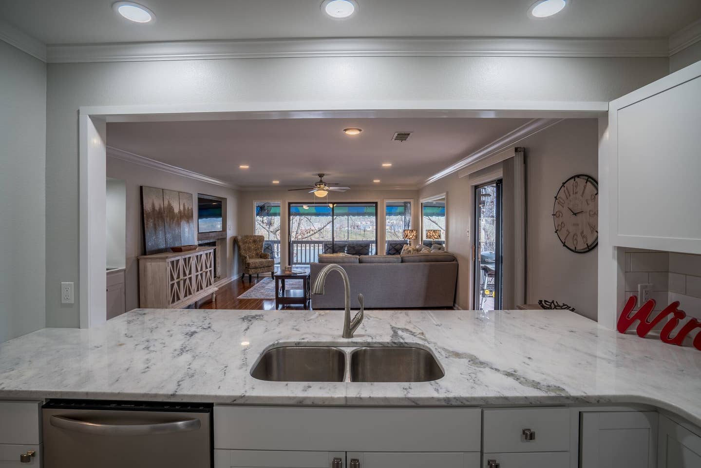 A kitchen with a sink and a clock on the wall.