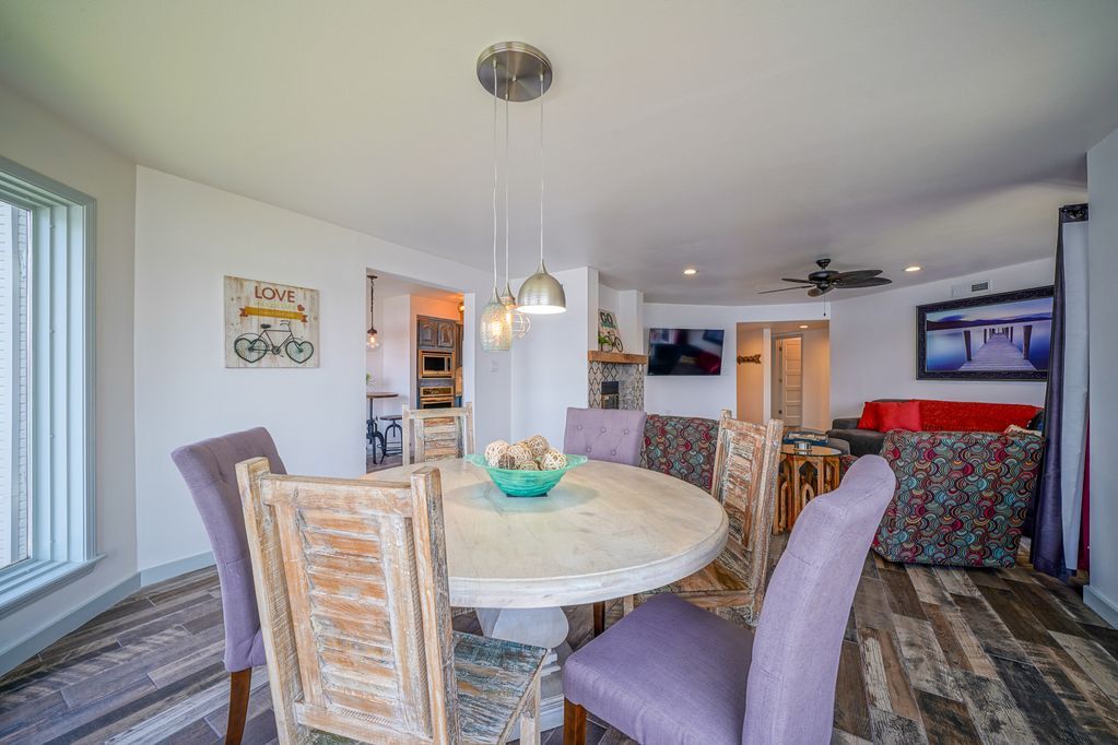 A dining room with a round table and purple chairs.