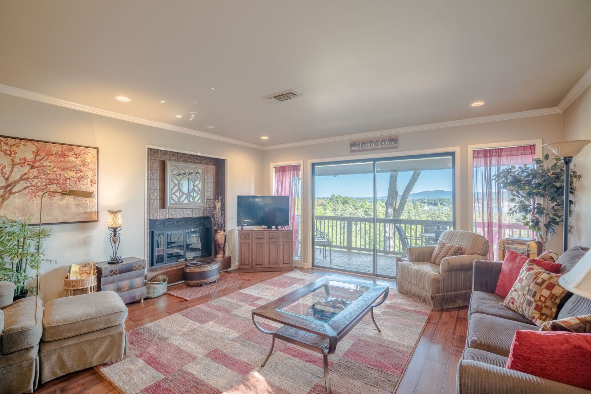 A living room with a couch , chairs , coffee table and television.