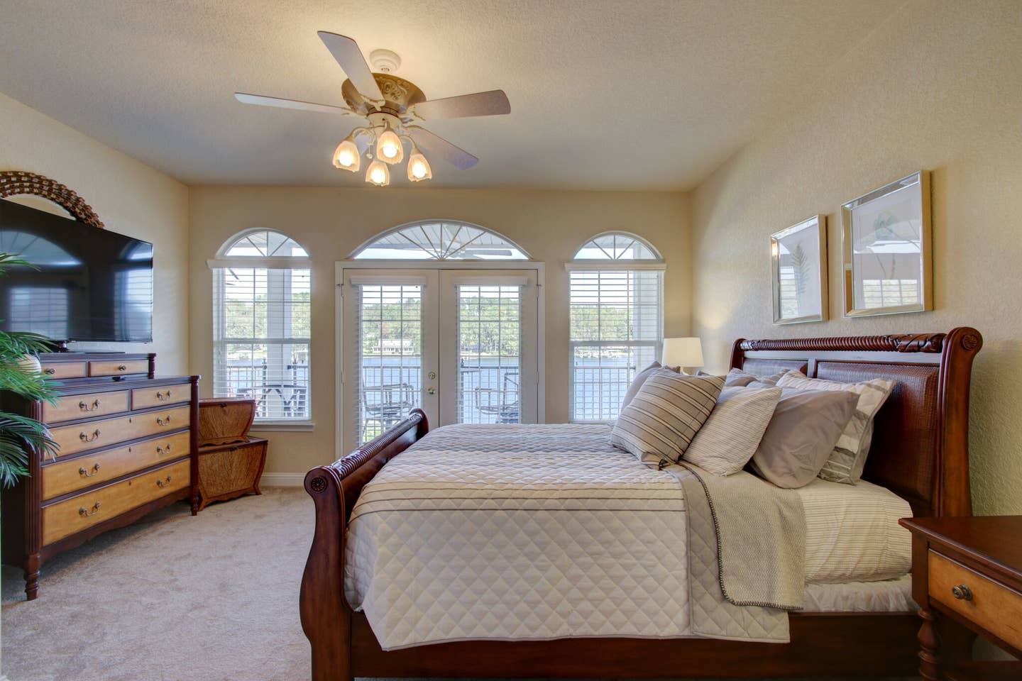 A bedroom with a sleigh bed and a ceiling fan