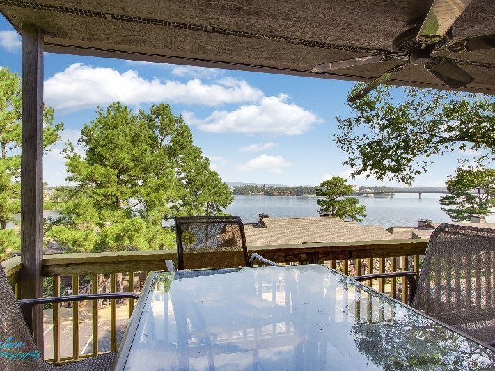 A patio with a table and chairs overlooking a lake
