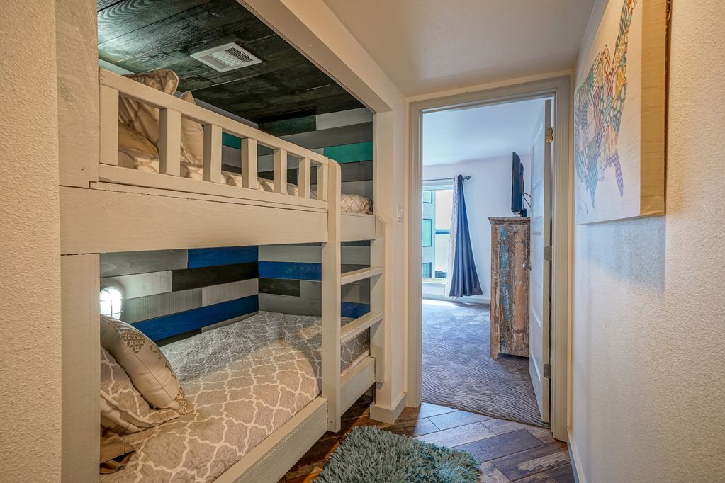 A bunk bed in a hallway leading to a bedroom.