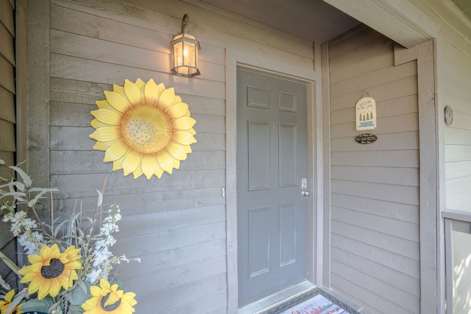The front door of a house with a sunflower on it.