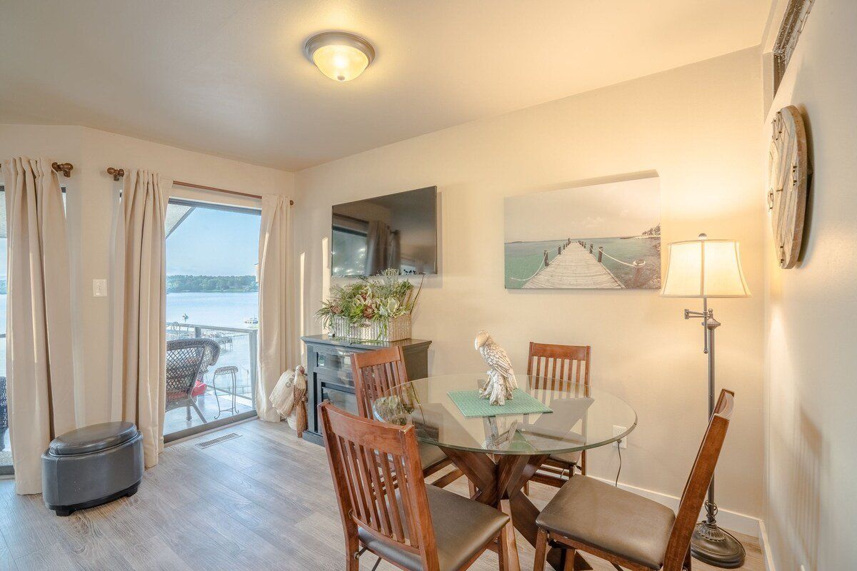 A living room with a dining table and chairs and a flat screen tv.