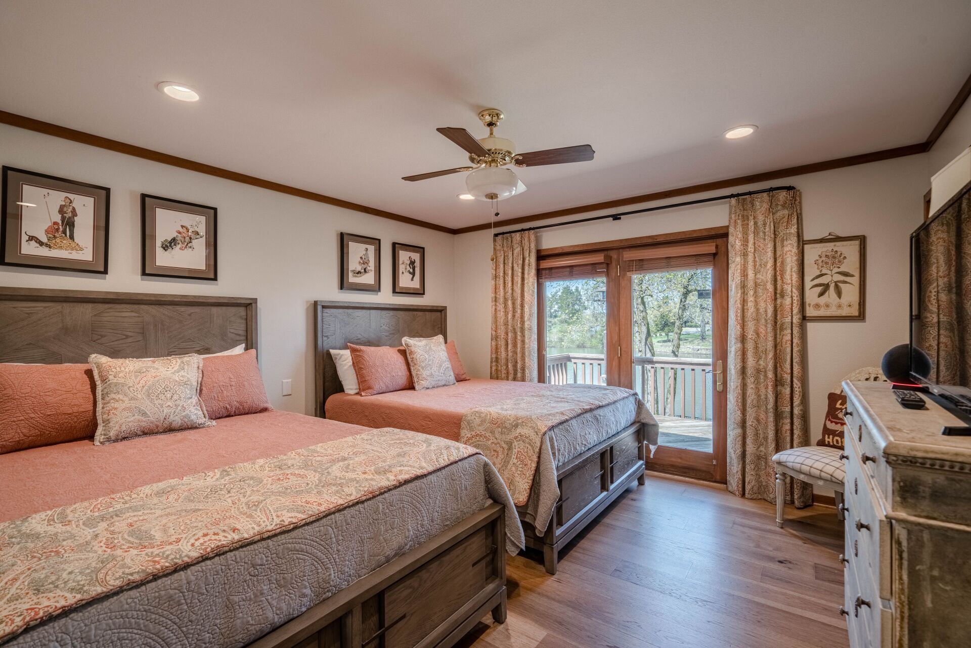A bedroom with two beds and a ceiling fan.