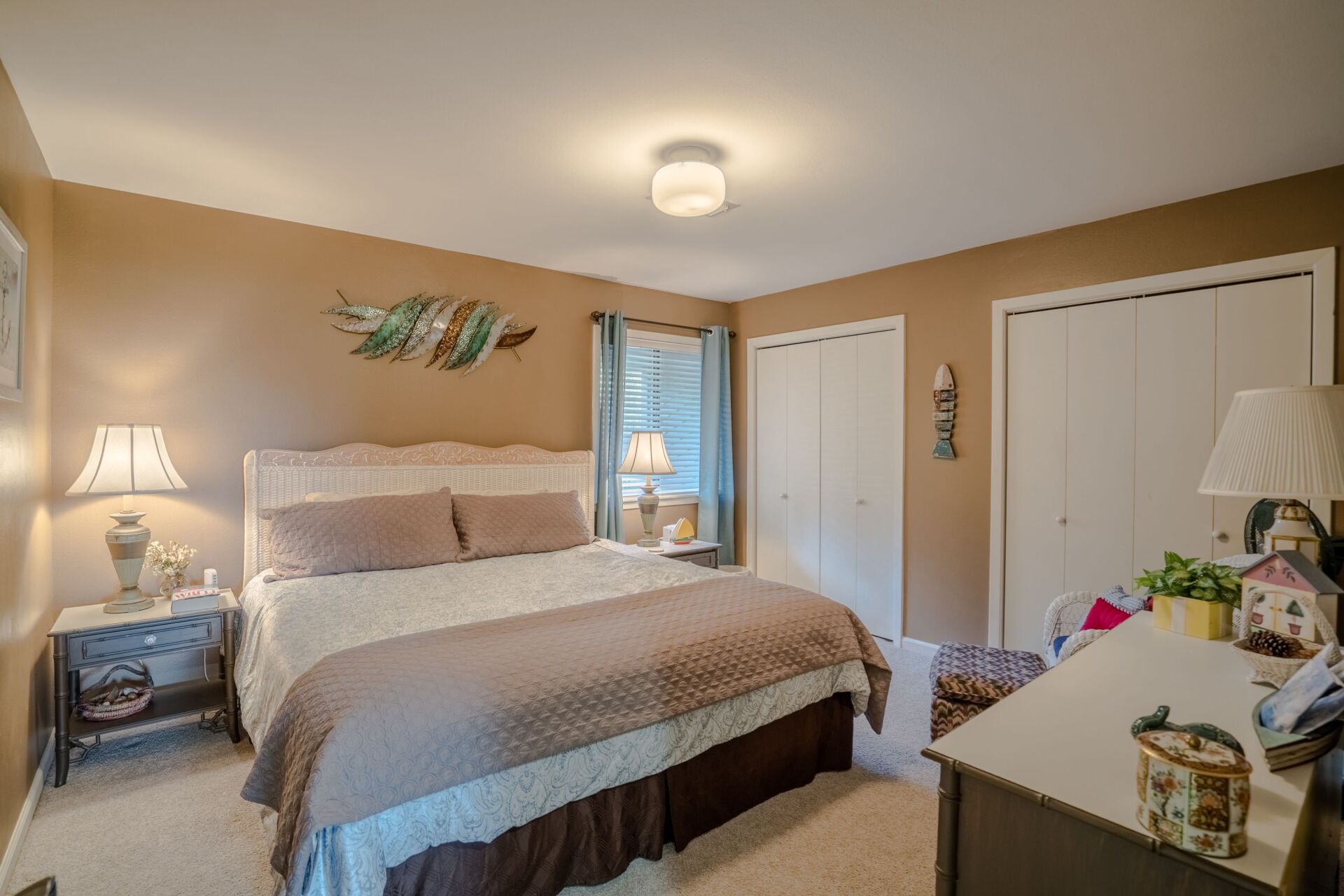 A bedroom with a king size bed and a desk.