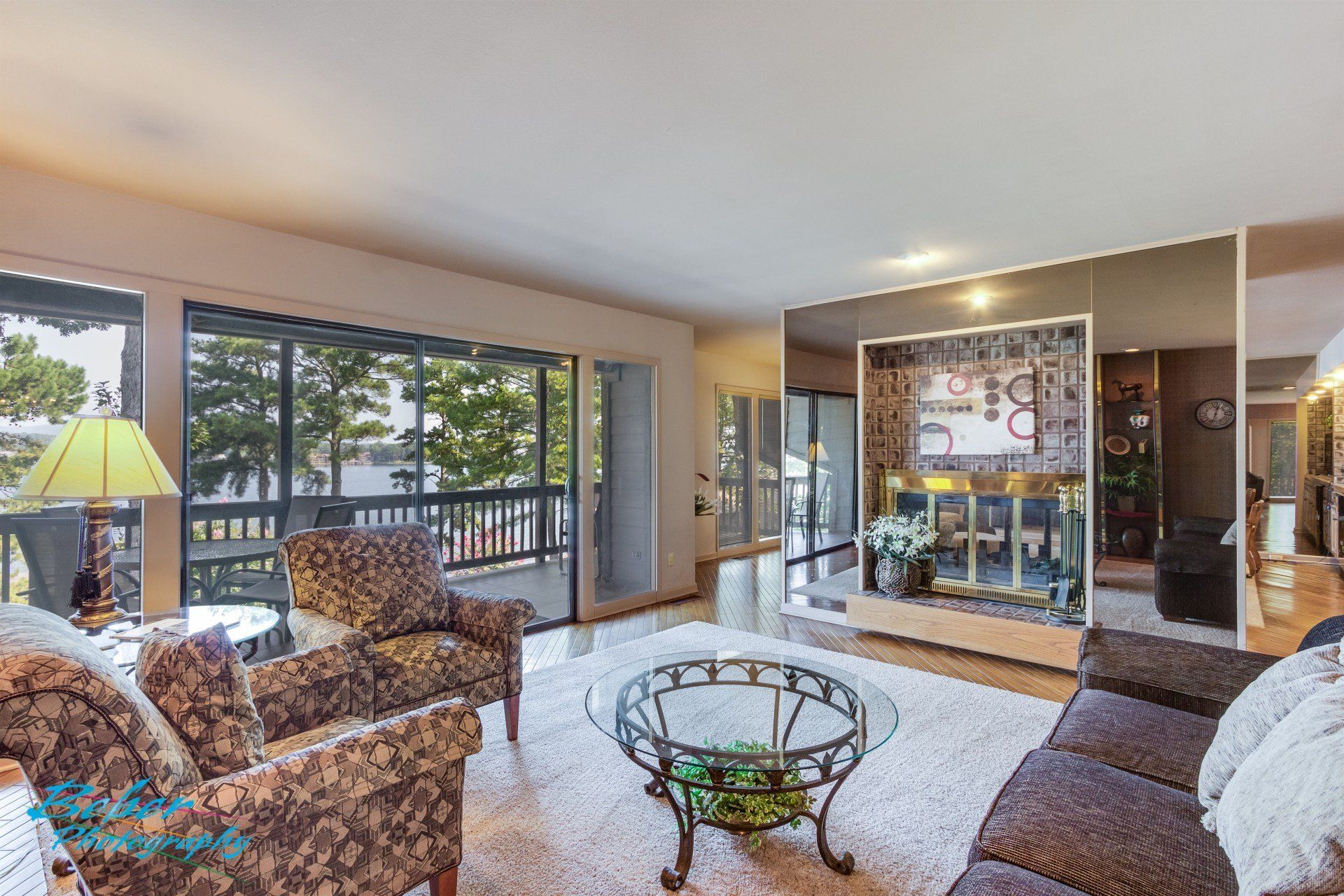A living room with a couch , chairs , a coffee table and a fireplace.