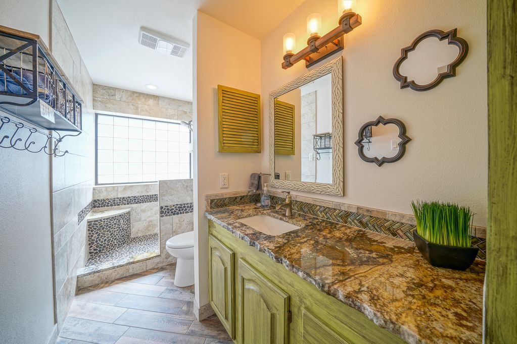 A bathroom with two sinks , a toilet , and a mirror.