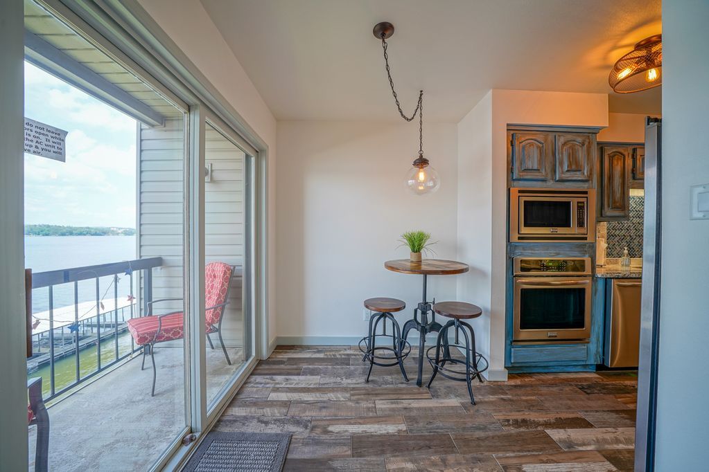 A dining room with a table and chairs and a view of a lake.