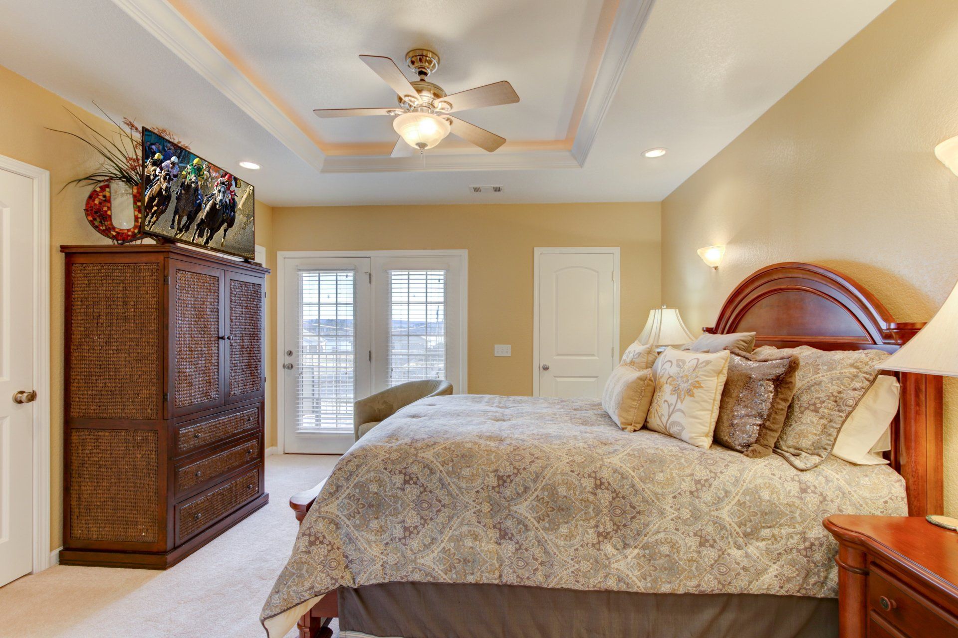 A bedroom with a large bed and a ceiling fan